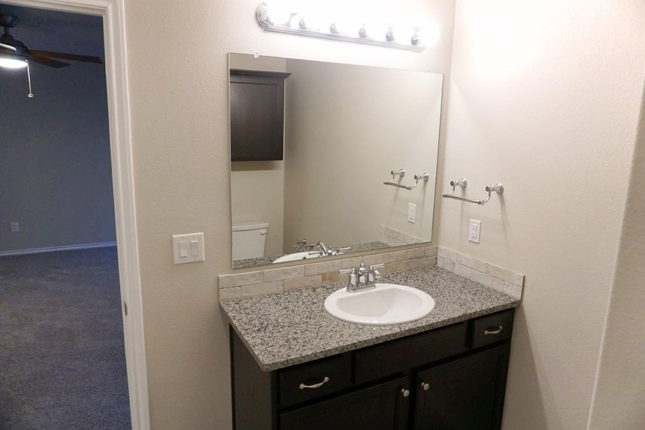 6822 40th Street Lubbock, TX 79407 - Photo 9 of 10 a sink and a mirror