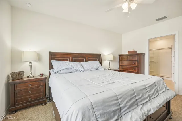 a bed sitting in a spacious bedroom next to a window