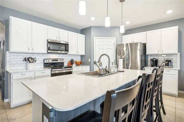 a kitchen with stainless steel appliances granite countertop a stove a refrigerator a sink a stove a dining table and chairs