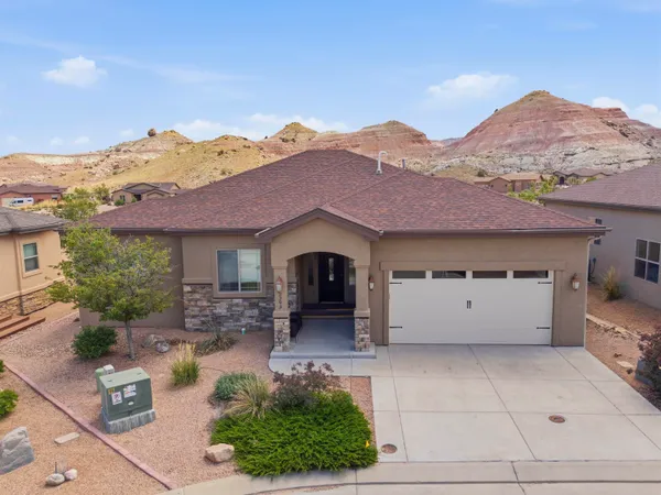 a front view of a house with a yard and mountain view in back