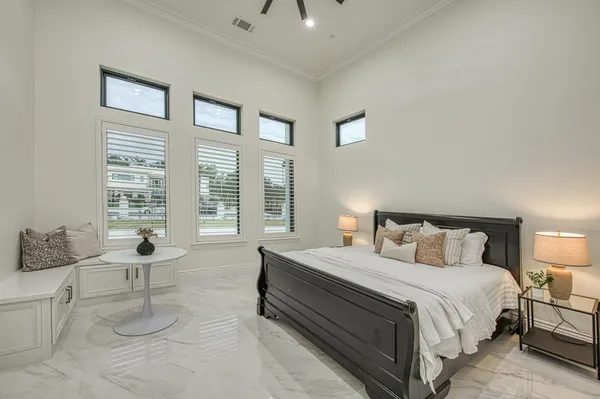 a spacious bedroom with a bed a chandelier and a couch