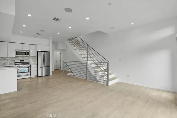 a view of entryway and kitchen with a sink
