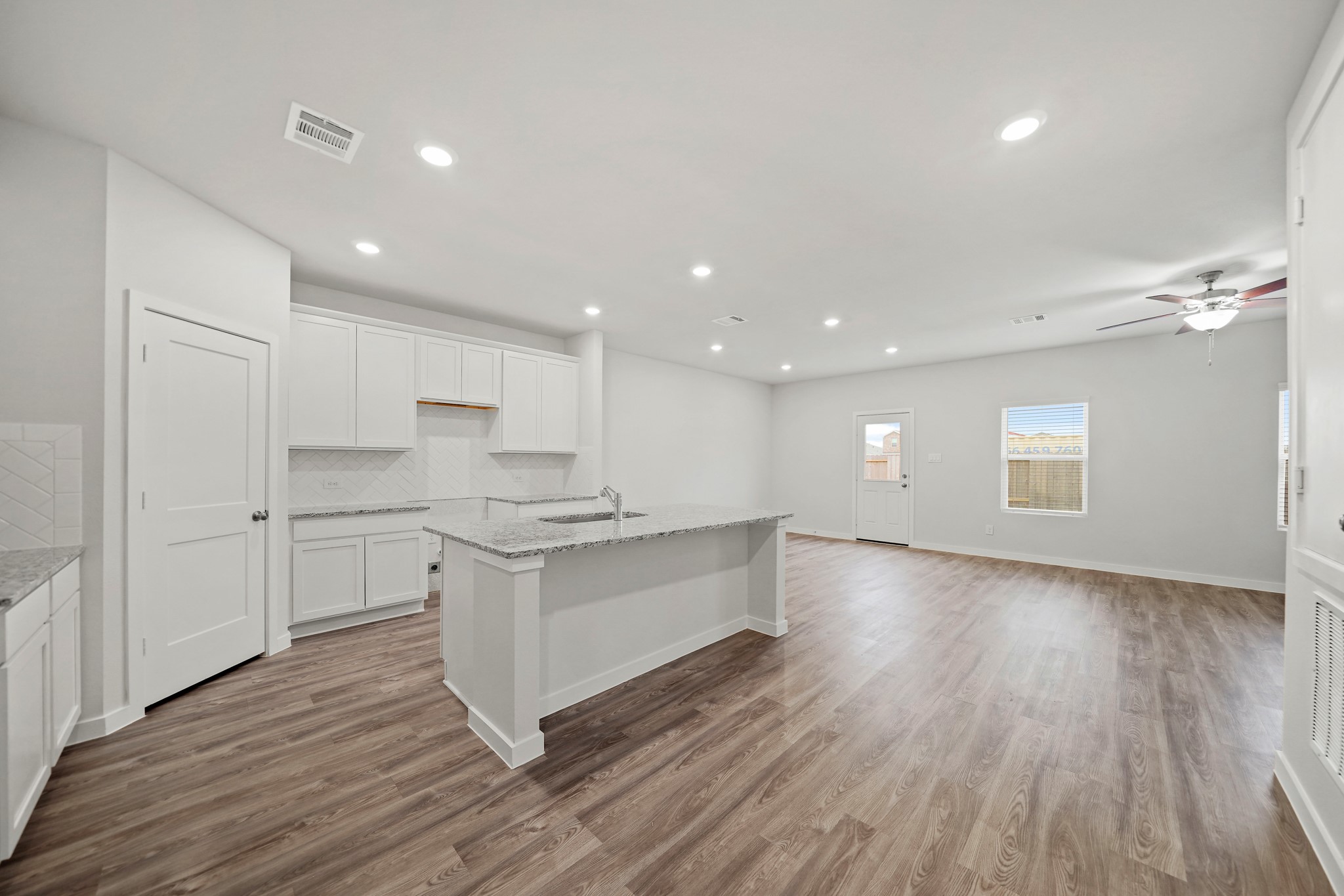 14405 Elmfield Lane Conroe, TX 77303 - Photo 4 of 22 a large kitchen with stainless steel appliances a large counter top a sink dishwasher a refrigerator and white cabinets