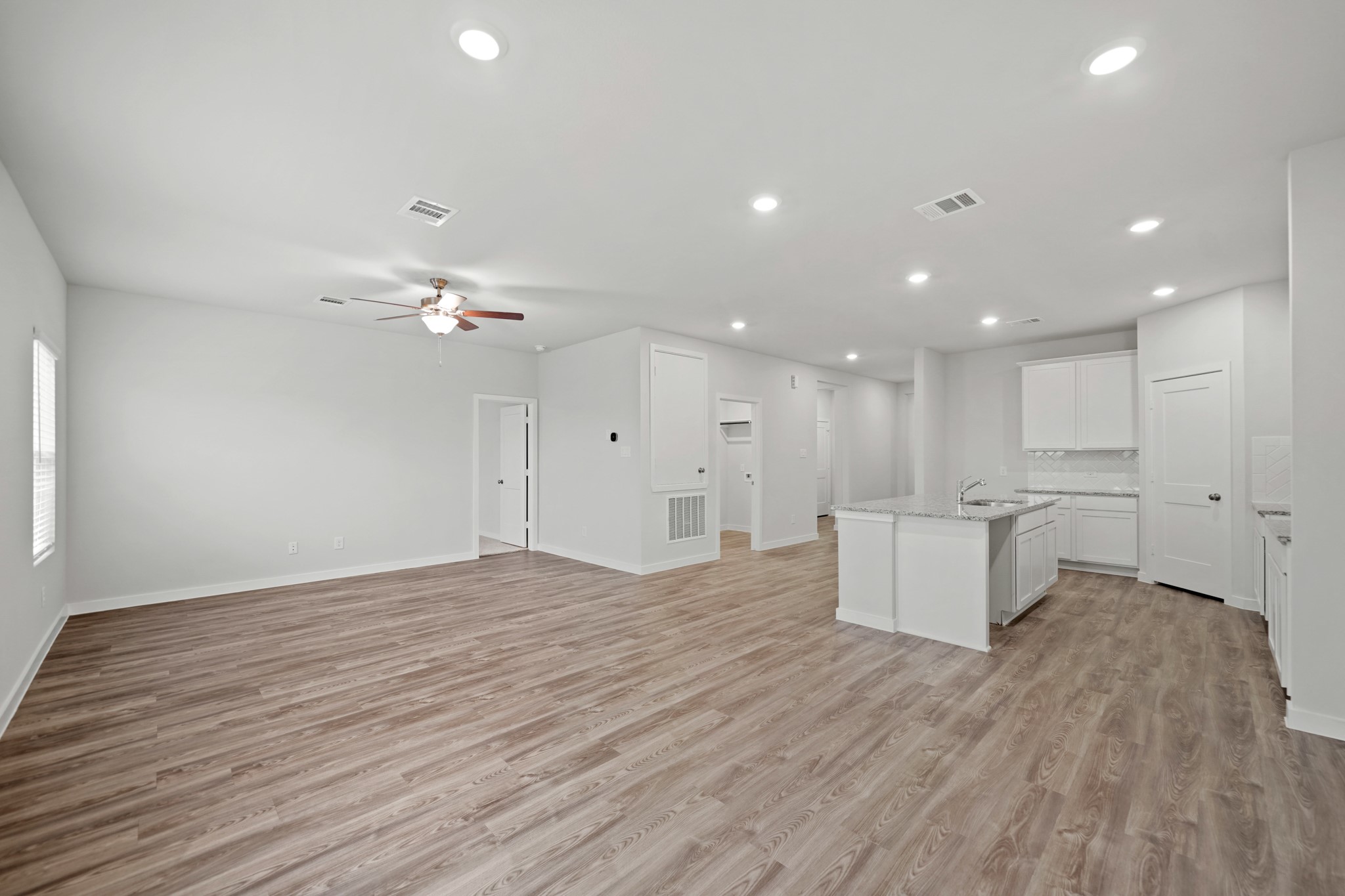 14405 Elmfield Lane Conroe, TX 77303 - Photo 6 of 22 a view of an empty room and kitchen with wooden floor