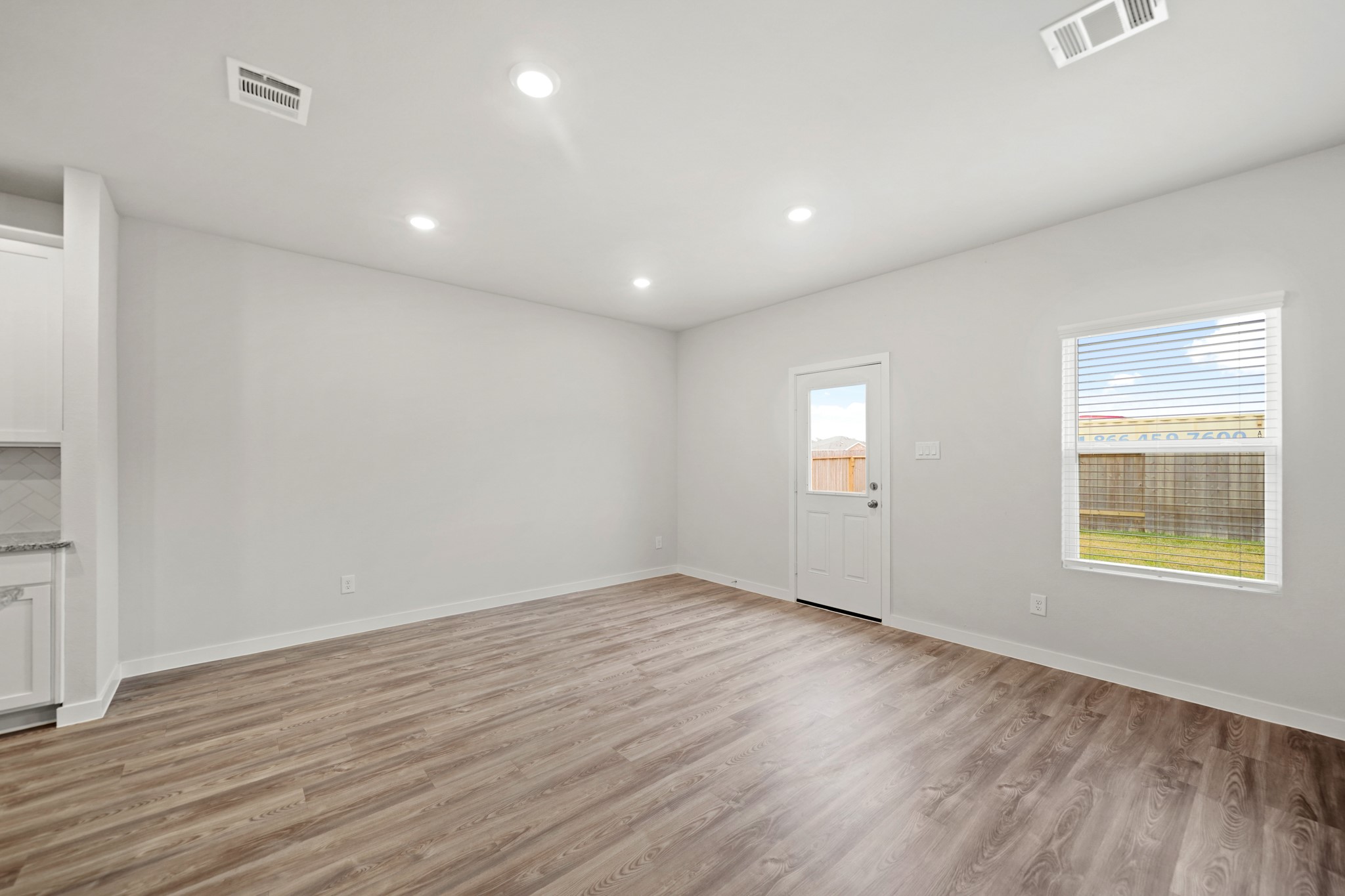 14405 Elmfield Lane Conroe, TX 77303 - Photo 7 of 22 an empty room with wooden floor and windows