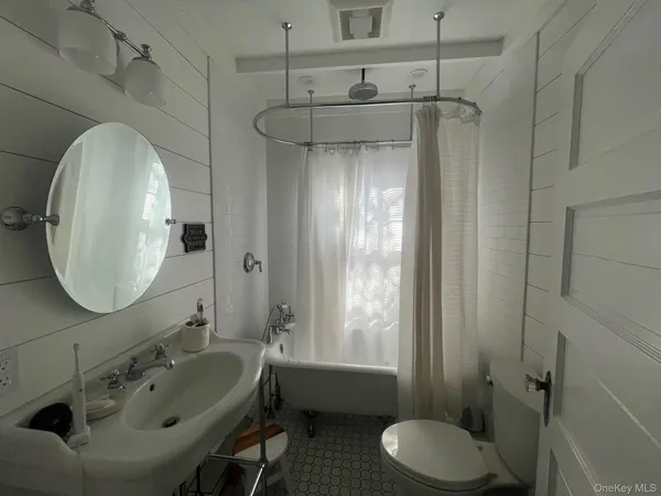 a bathroom with a sink and mirror with toilet