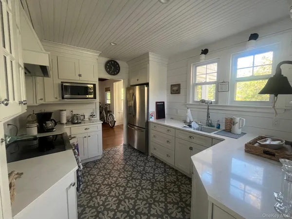 a large kitchen with kitchen island granite countertop a sink and dishwasher a stove top oven with wooden floor