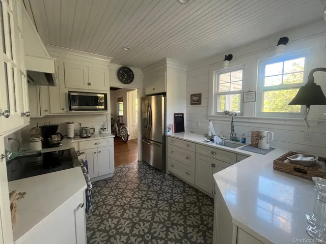 a large kitchen with kitchen island granite countertop a sink and dishwasher a stove top oven with wooden floor