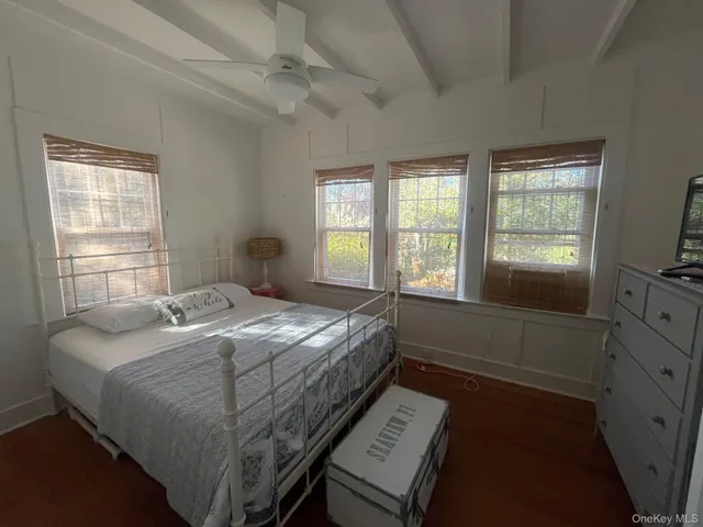 a bedroom with a bed and a flat tv screen on the dresser