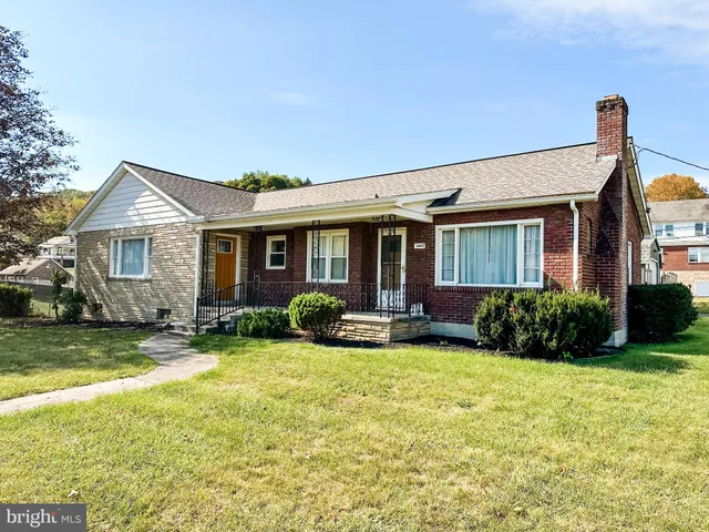 a view of a house with a yard and sitting area