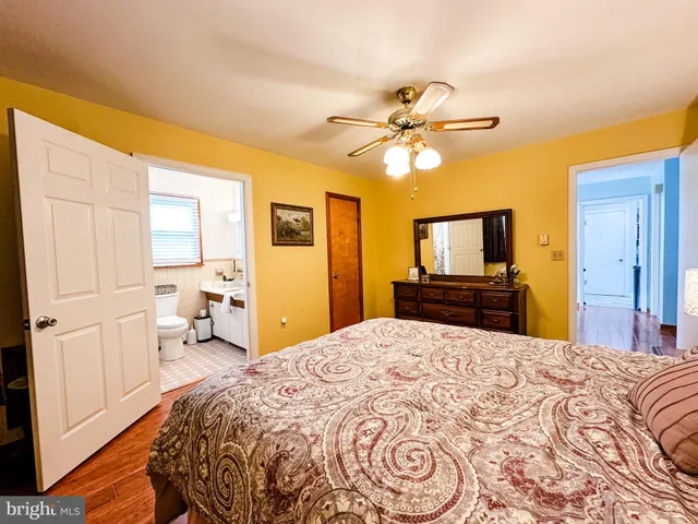 a large bedroom with a bed and a flat screen tv