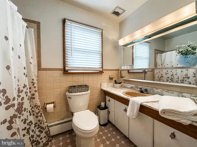 a bathroom with a granite countertop toilet a sink and a bathtub