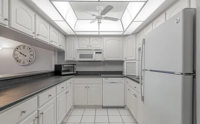 a kitchen with granite countertop white cabinets and a window