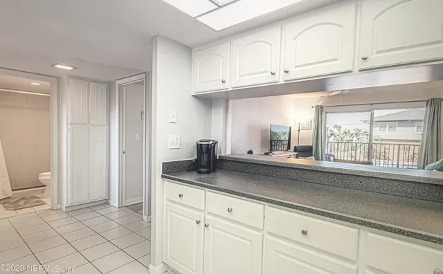 a kitchen with granite countertop white cabinets stainless steel appliances and a sink