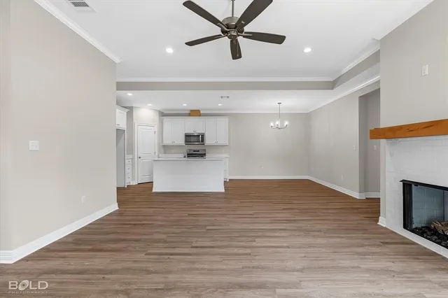 a view of empty room with wooden floor and a ceiling fan