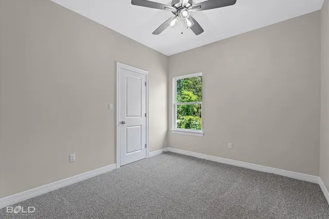 an empty room with a window and a fan