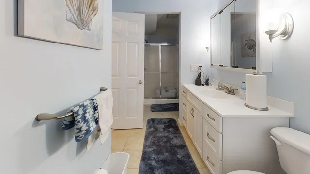 a bathroom with a sink a toilet and shower