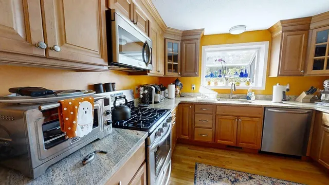 a kitchen with stainless steel appliances granite countertop a stove a sink and a microwave
