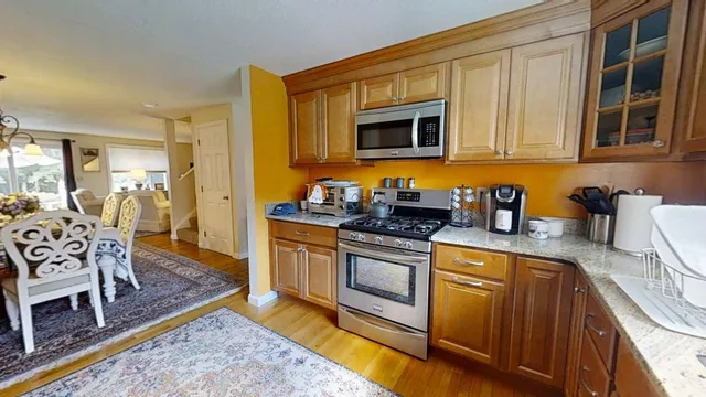 a kitchen with stainless steel appliances granite countertop a stove a sink and a microwave