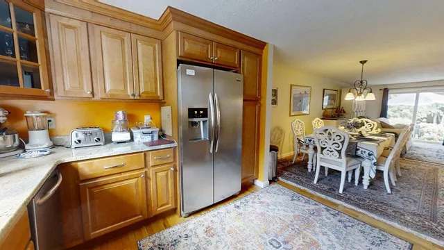 a kitchen with stainless steel appliances granite countertop a refrigerator a sink a stove and island
