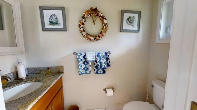 a bathroom with a granite countertop sink mirror vanity and toilet
