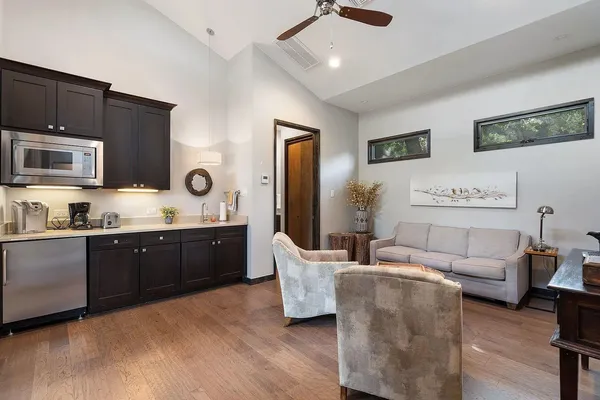 a large living room with stainless steel appliances granite countertop furniture a fireplace and a projector