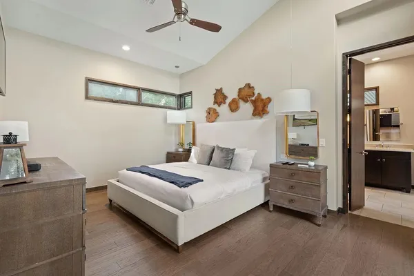 a white bed sitting in a room next to a window