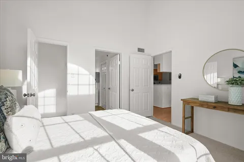 a bedroom with a bed mirror and a window