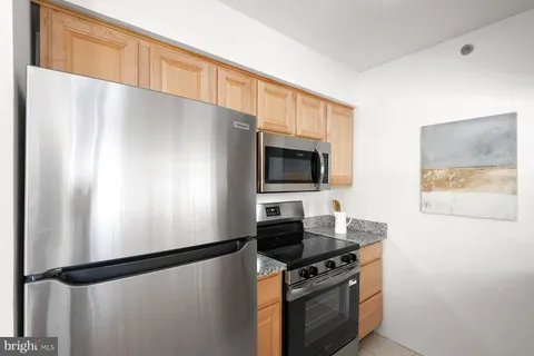 a kitchen with stainless steel appliances a refrigerator and a stove top oven
