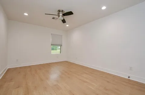 an empty room with a window and a ceiling fan