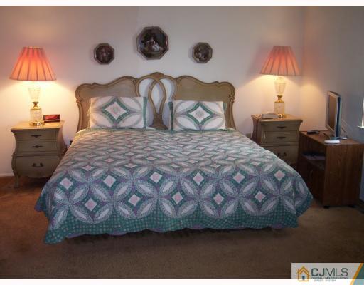 8006 Hana Road Edison, NJ 08817 - Photo 4 of 9 a bedroom with a bed and a lamp