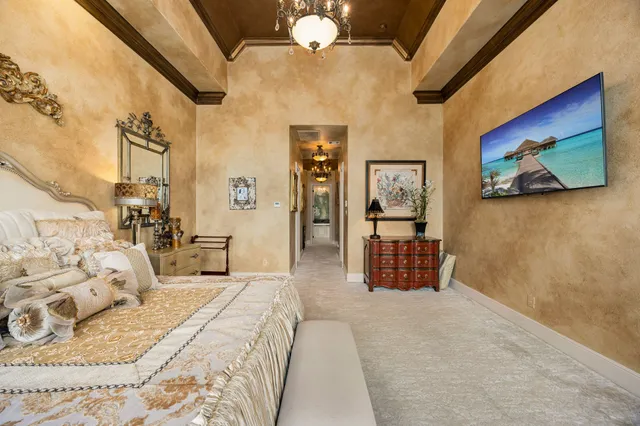 a bedroom with a large bed and a chandelier