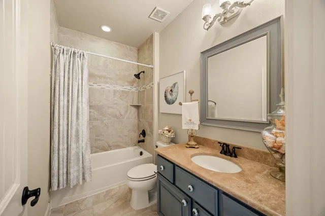 a bathroom with a granite countertop sink toilet mirror and shower