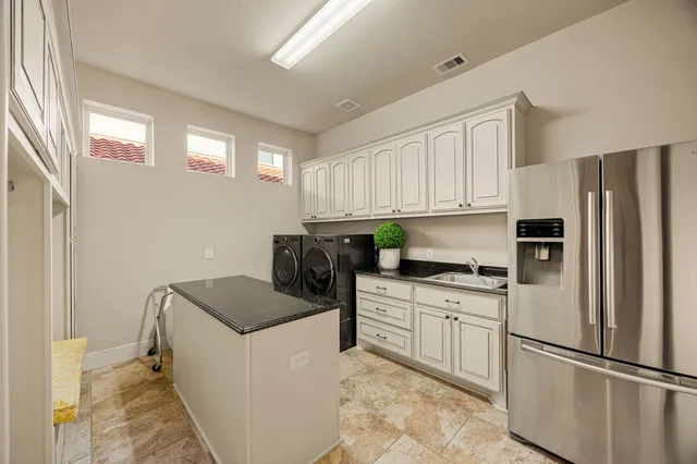 a kitchen with stainless steel appliances granite countertop a refrigerator sink and stove