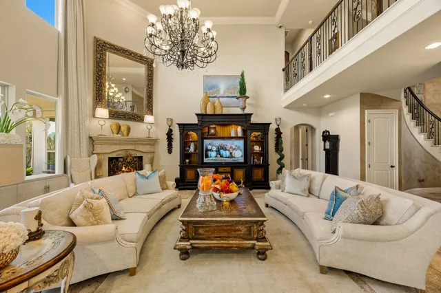 a living room with furniture a fireplace and chandelier