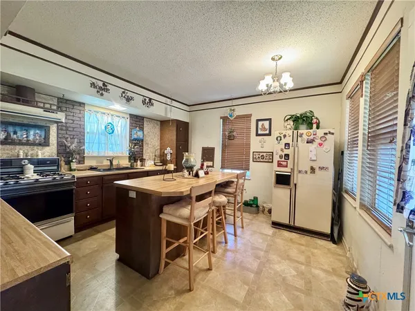 a kitchen with stainless steel appliances granite countertop sink stove and refrigerator