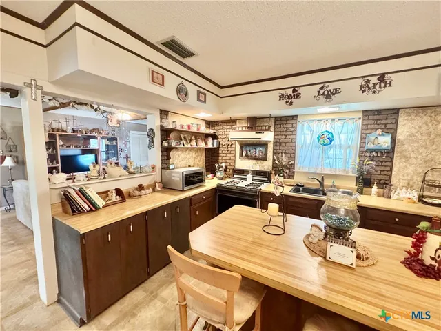 a kitchen with a sink a stove and cabinets