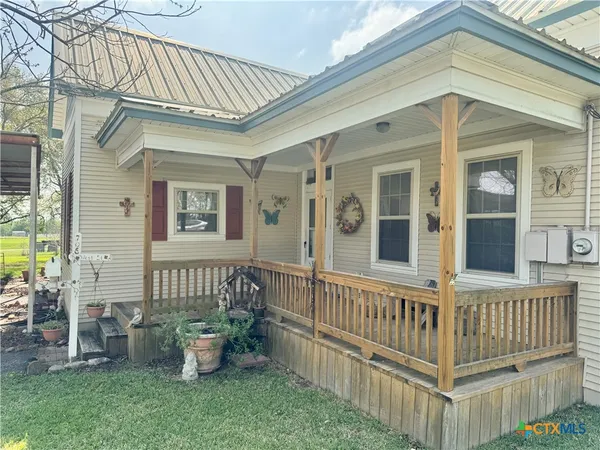 a view of a house with a small yard and wooden floor
