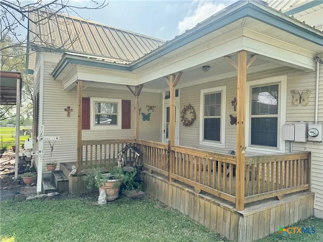 a view of a house with a small yard and wooden floor