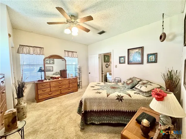 a spacious bathroom with a double vanity sink a toilet and a mirror