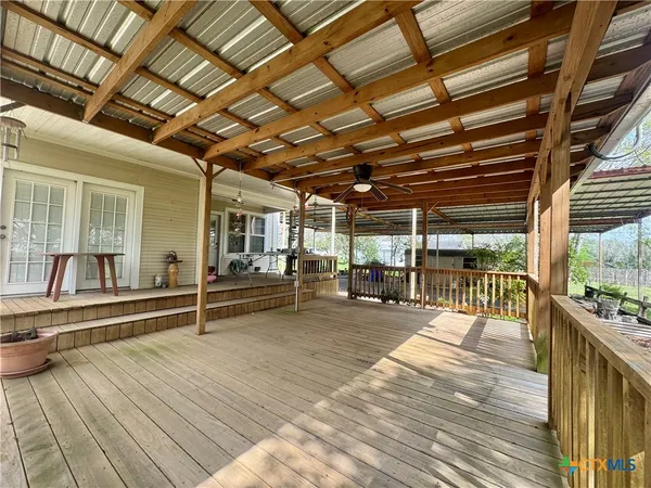 a backyard of a house with wooden floor and outdoor seating