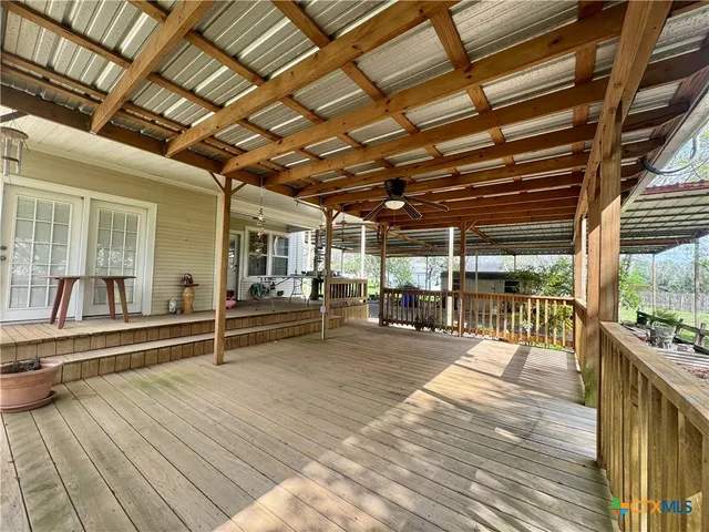 a backyard of a house with wooden floor and outdoor seating