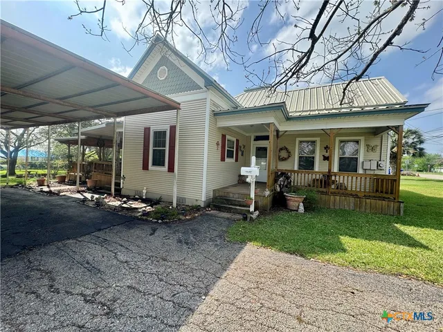 a view of a backyard with table and chairs under an umbrella with a couch
