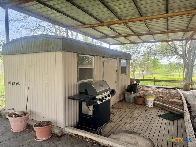 a view of a patio with table and chairs under an umbrella