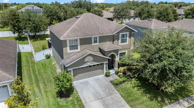 an aerial view of a house with yard and green space
