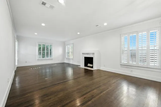 an empty room with wooden floor and fireplace