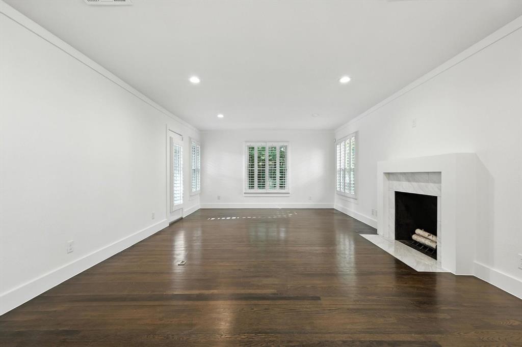 6116 St Moritz Avenue Dallas, TX 75214 - Photo 14 of 40 a view of empty room with wooden floor and fireplace