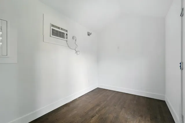 a view of a small space with wooden floor and a window