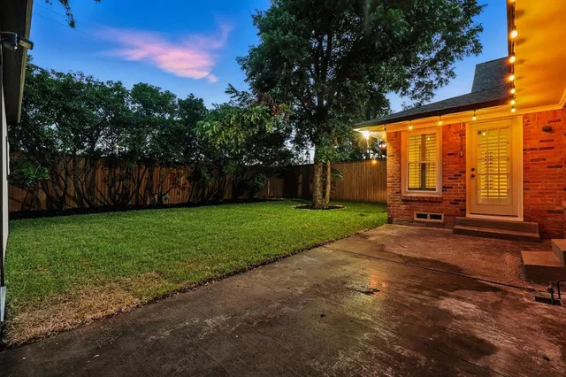 a view of a house with backyard and a tree