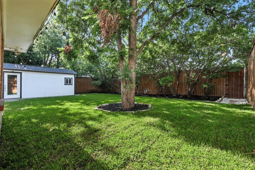 6116 St Moritz Avenue Dallas, TX 75214 - Photo 34 of 40 a view of a backyard with large trees and a barn